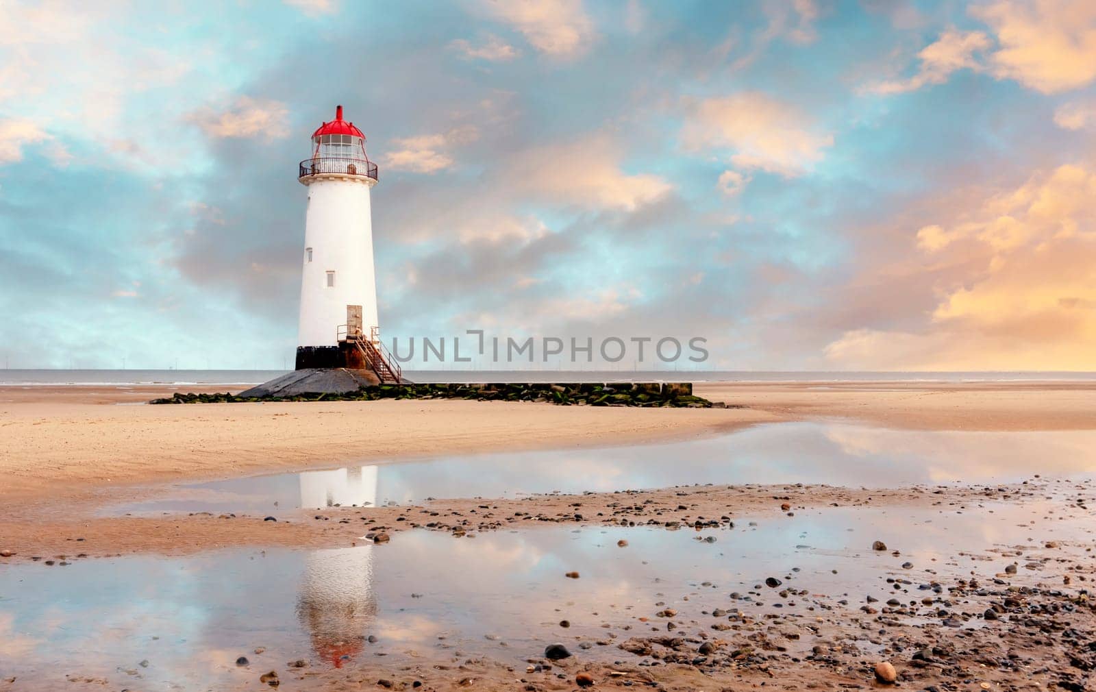 view of a lighthouse standing at the coast of Wales  the North Sea  at sinrise, United Kingdom