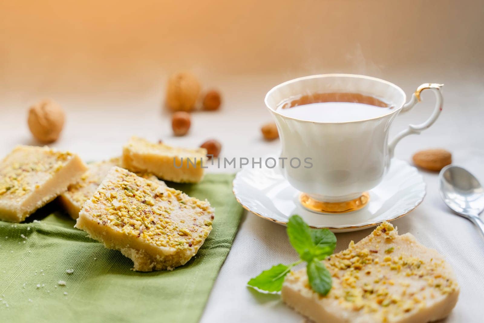 tea,  cakes, chocolate pieces, halva on the table by Iryna_Melnyk