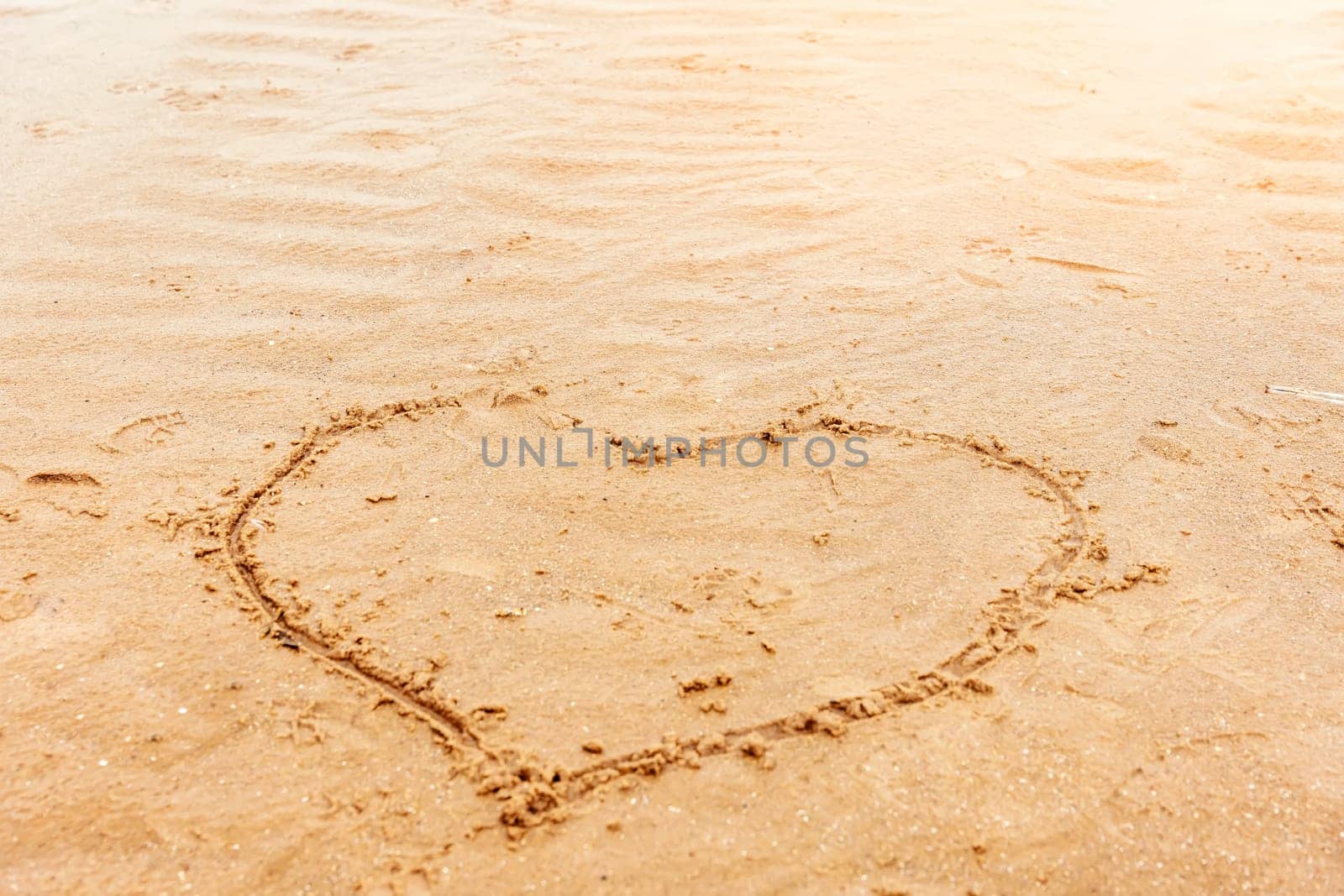 a painted heart on the sand on the beach by Iryna_Melnyk