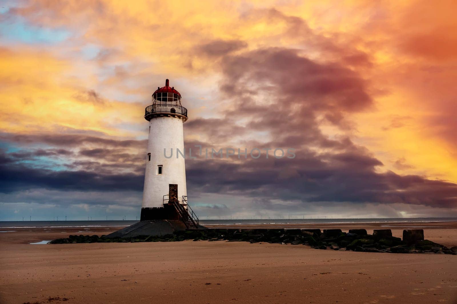 view of a lighthouse standing at the coast of Wales the North Sea at sinrise, United Kingdom