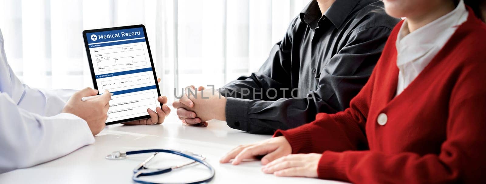 Couple attend fertility consultation with gynecologist at hospital as part family planning care for pregnancy. Loving husband and wife support each other through the doctor appointment. Panorama Rigid