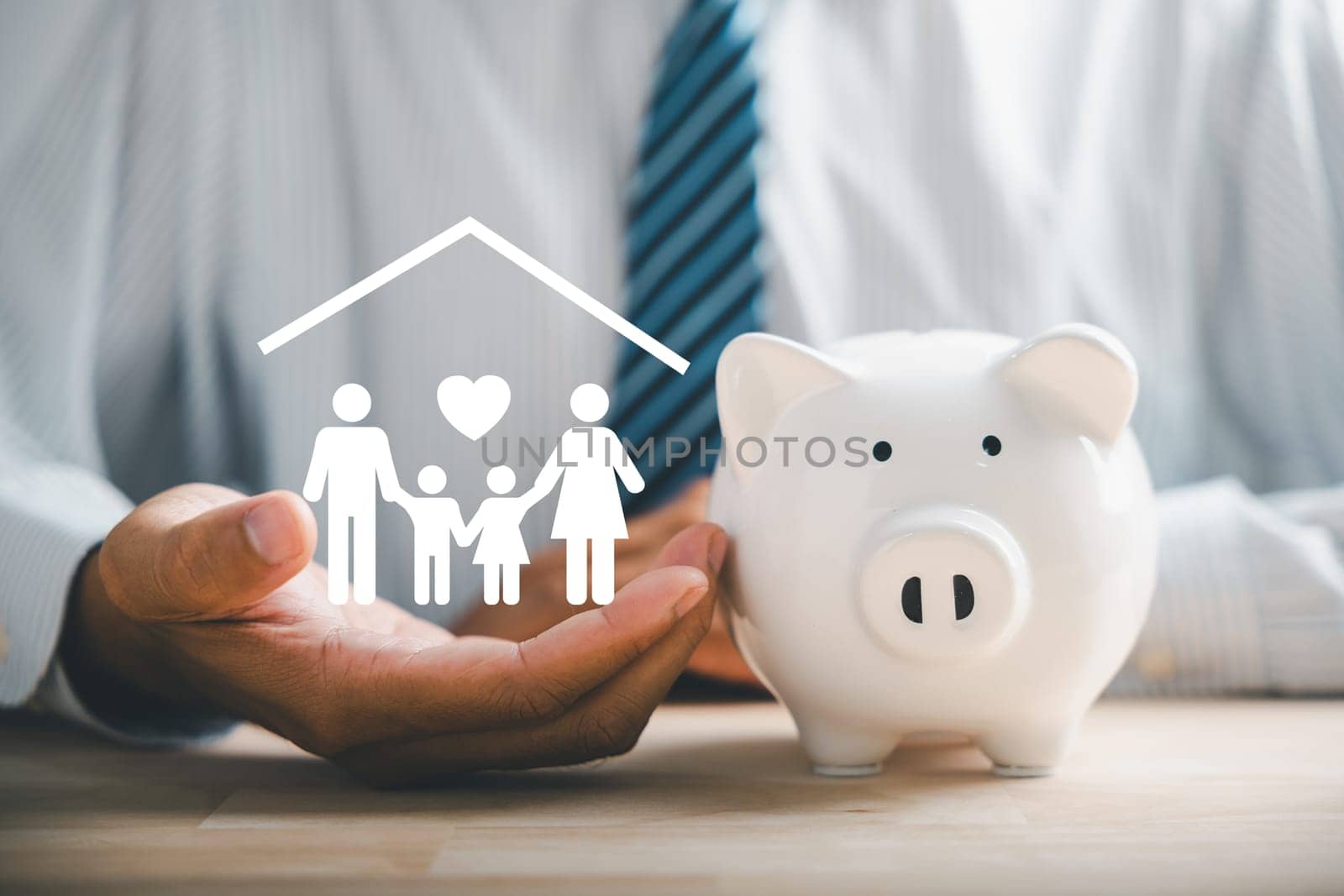 Businessman protects piggybank and holds family icon, showcasing saving, donation, family finance approaches. Illustrating mes of charity, fundraising, superannuation, and financial crisis concept.