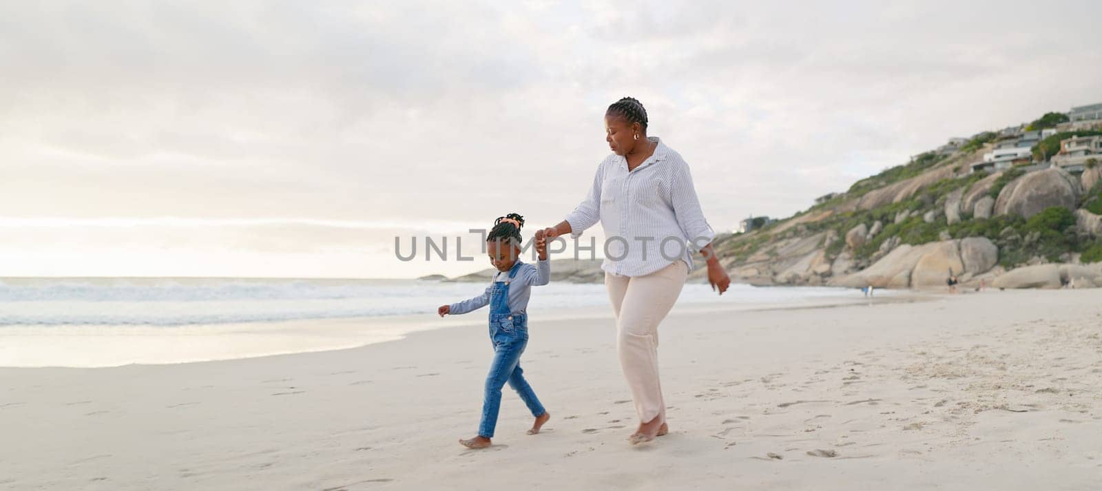 Black family, mother and daughter holding hands, walk on beach and bonding with love and care outdoor. Happiness, freedom and travel, woman and young girl on holiday with trust and support in nature.
