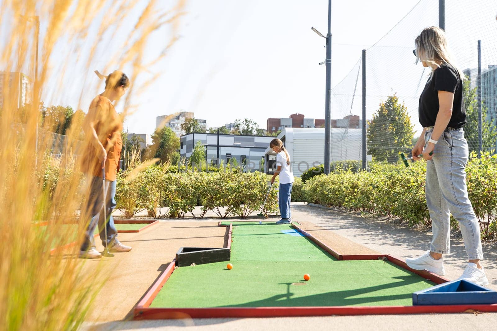 golfers with parents playing golf at sunny day. High quality photo