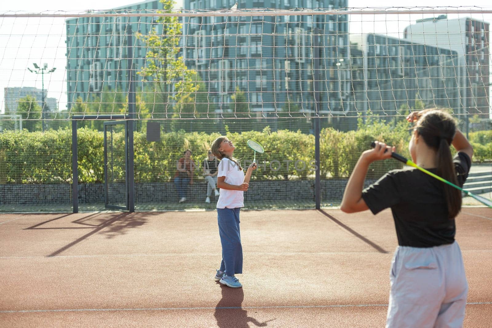 Two girls with badminton rackets on the football field. High quality photo