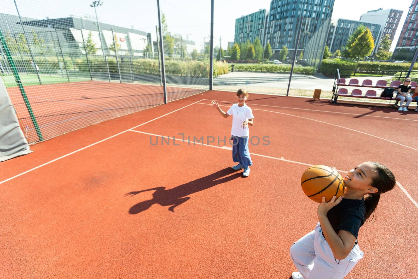 Children and sports. Teenage girl playing basketball on the playground. High quality photo