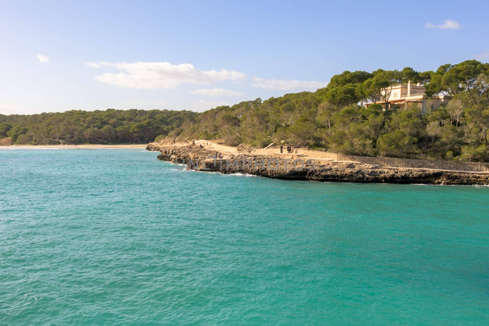 Coastal landscape with a point jutting into turquoise waters under clear skies, cala mondrago, mallorca, balearic island, spain,