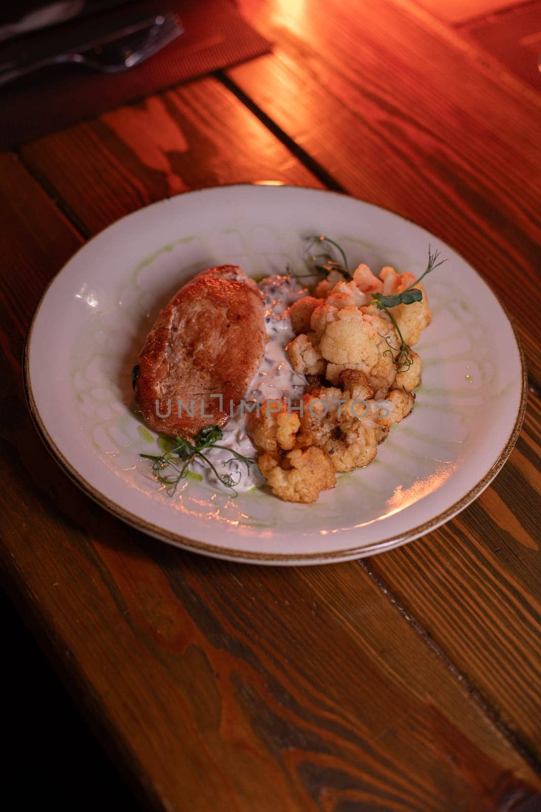 Baked turkey and cauliflower are a delicious dish on the menu at the restaurant. A beautiful and delicious photo for a menu, culinary website, or an advertisement for catering establishments.