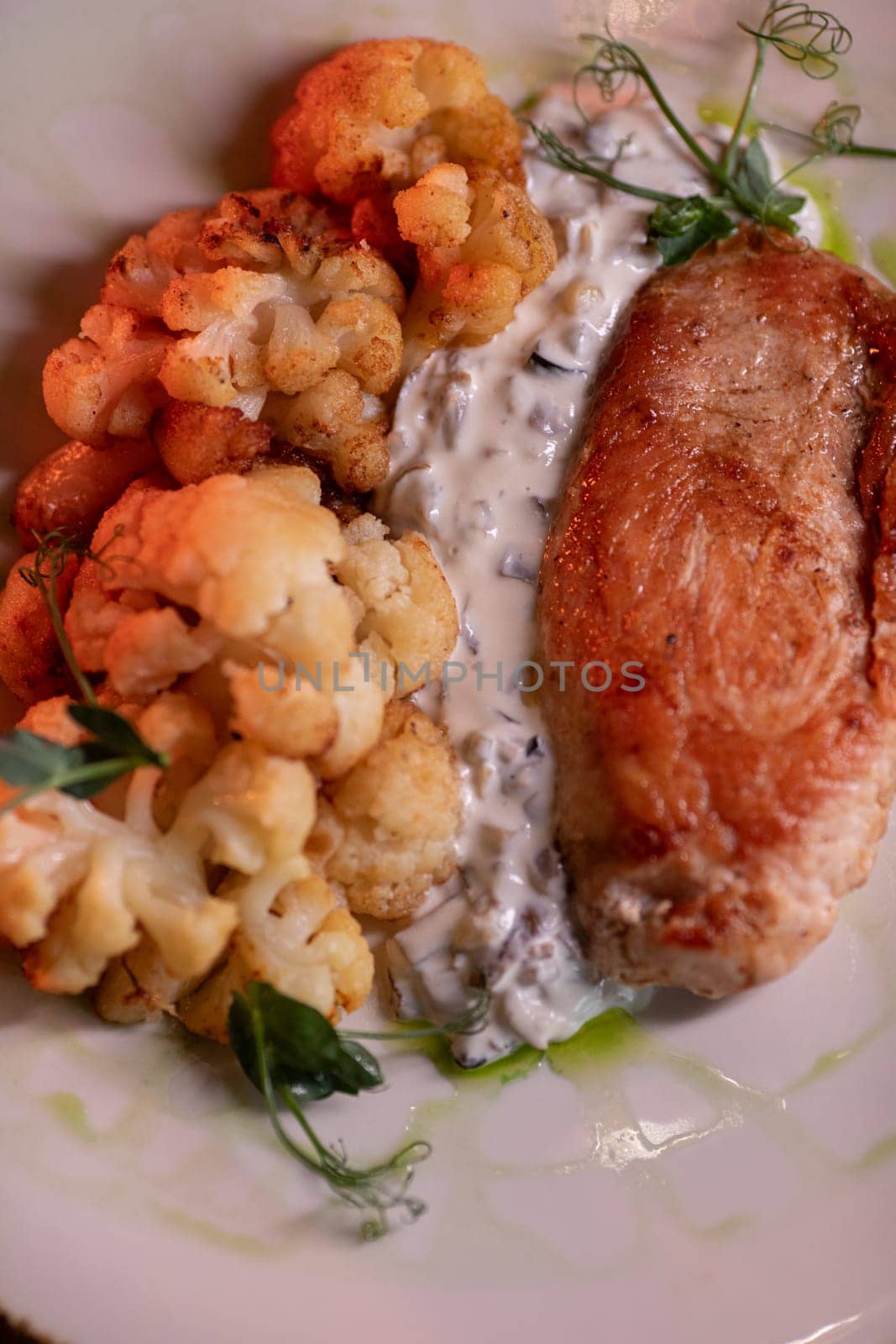 Baked turkey and cauliflower are a delicious dish on the menu at the restaurant. A beautiful and delicious photo for a menu, culinary website, or an advertisement for catering establishments.