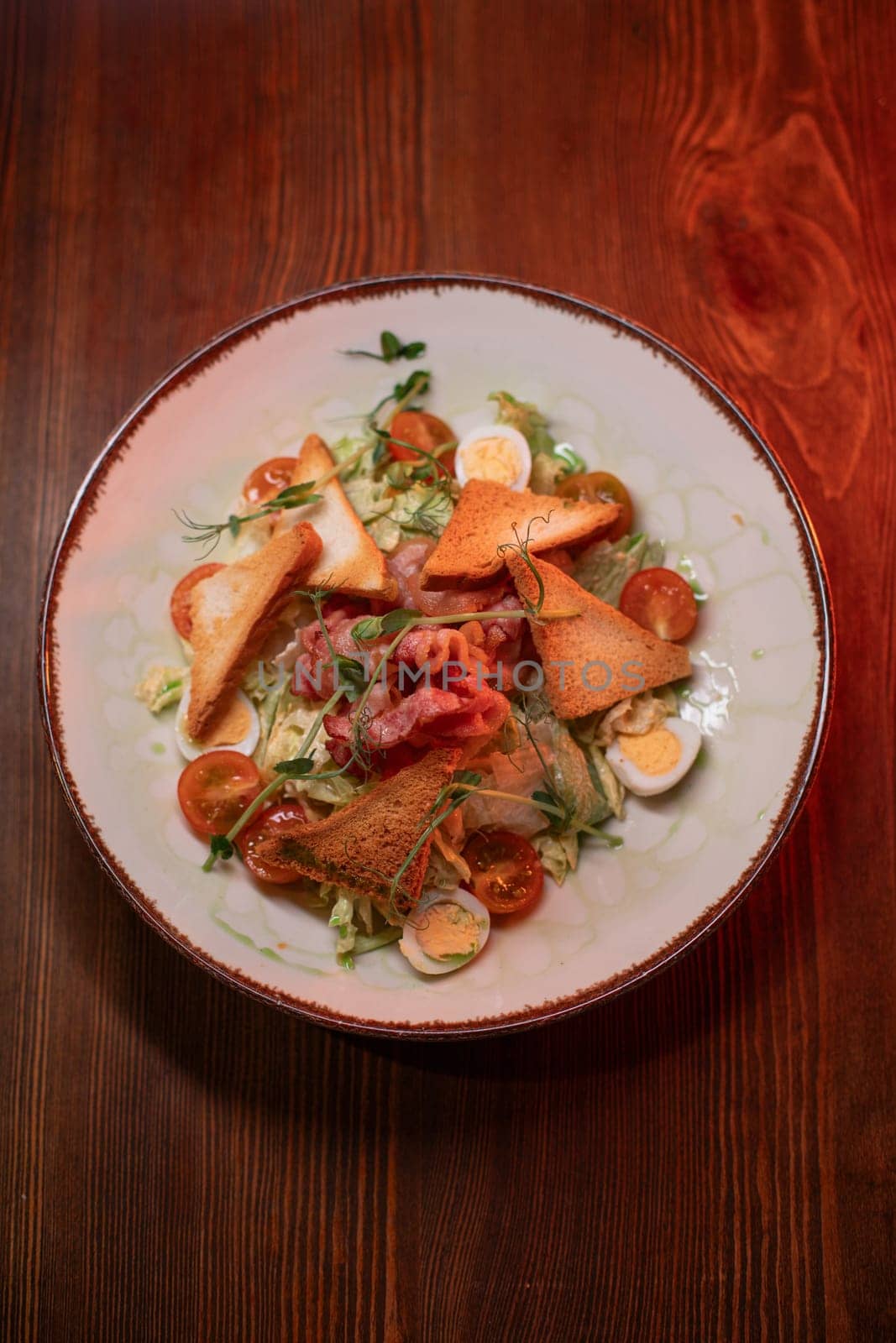 Caesar salad with bacon is mouthwatering and delicious. A beautiful perfect photo for a cafe or restaurant menu, advertisement, culinary website. Suitable for design.