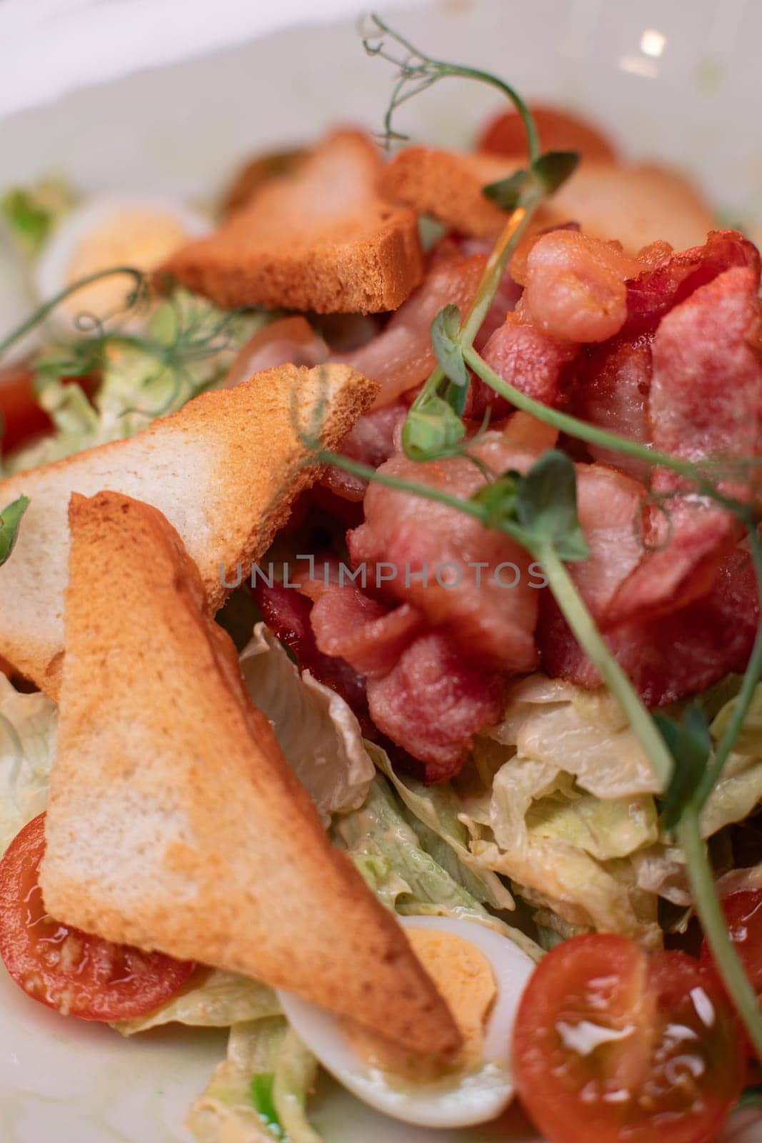 Caesar salad with bacon is mouthwatering and delicious. A beautiful perfect photo for a cafe or restaurant menu, advertisement, culinary website. Suitable for design.