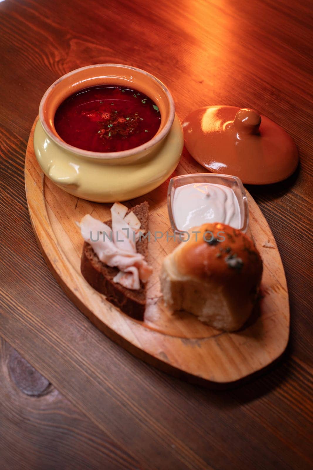 Restaurant dish borscht, delicious bread with bacon, sour cream, bun. A delicious photo for a menu, culinary website, or an advertisement for catering establishments
