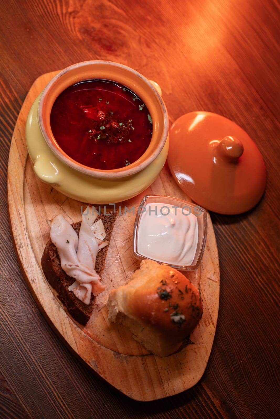 Restaurant dish borscht, delicious bread with bacon, sour cream, bun. A delicious photo for a menu, culinary website, or an advertisement for catering establishments