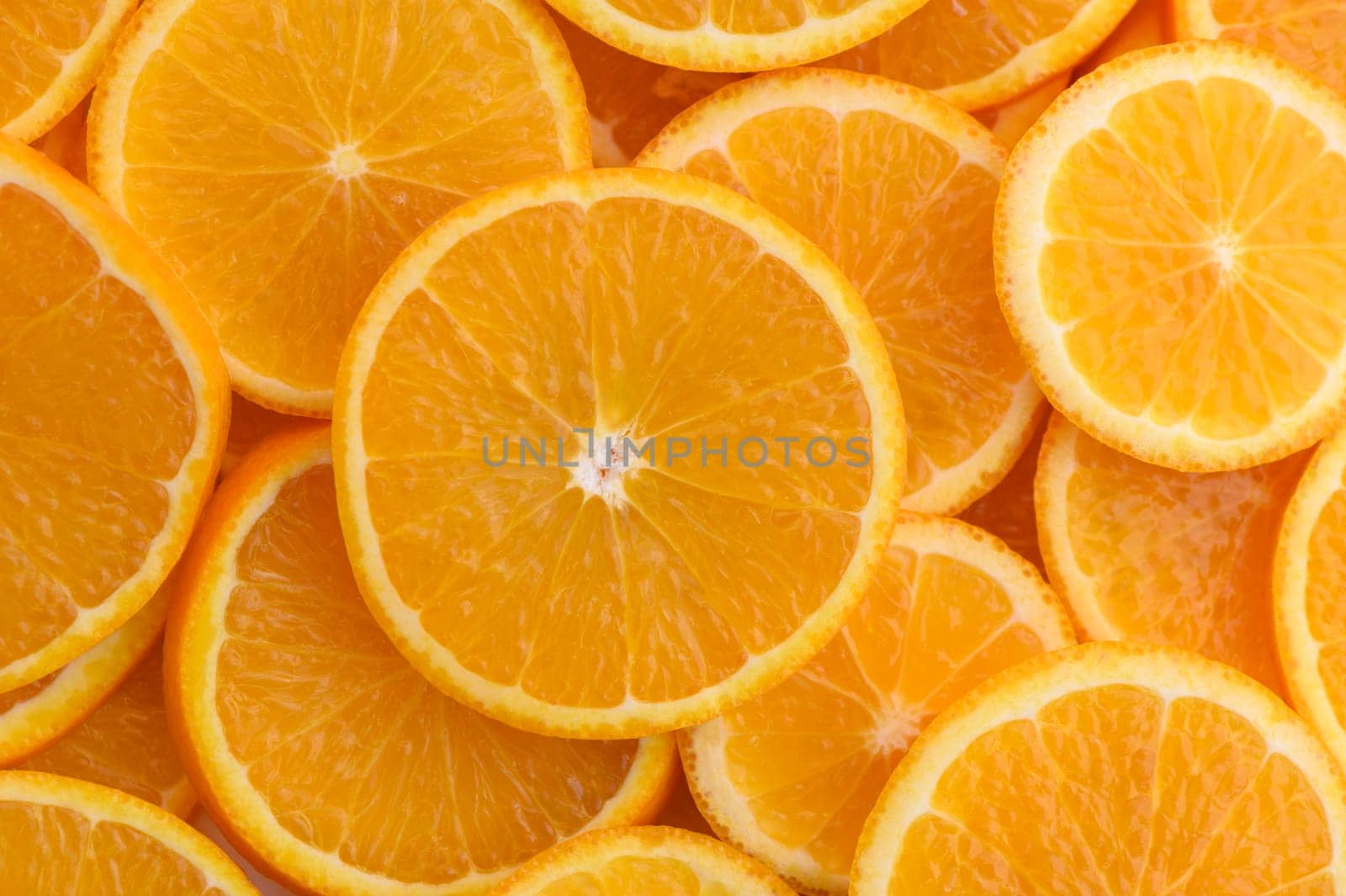 Overlapping juicy orange slices create a sunny, cheerful scene that invites freshness.