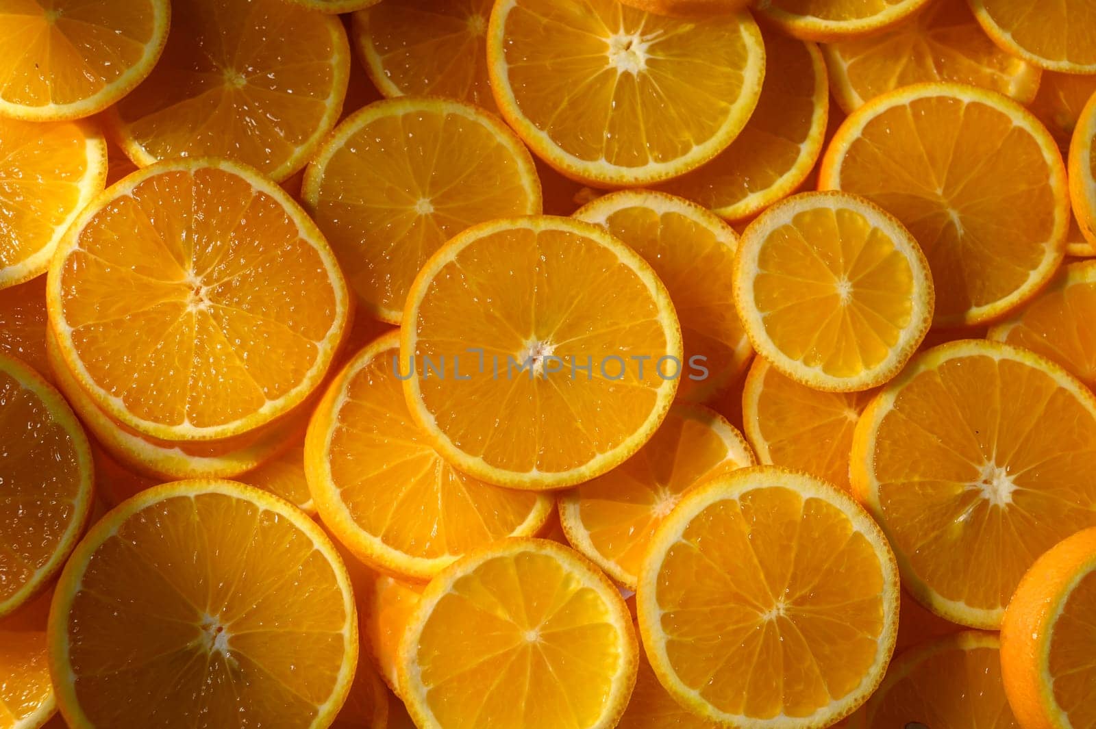 Freshly cut orange slices radiate warmth and color, inviting a sense of joy and health into a sunny kitchen.