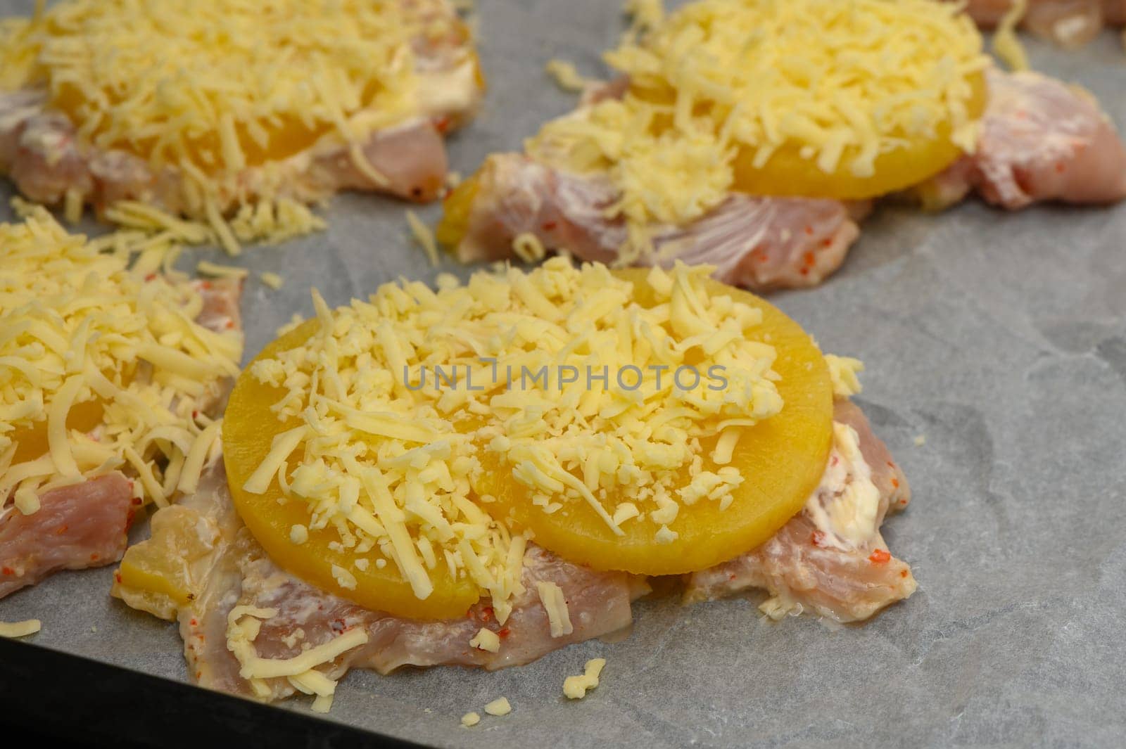 Slices of chicken are layered with sweet pineapple and shredded cheese, waiting to be baked to perfection.