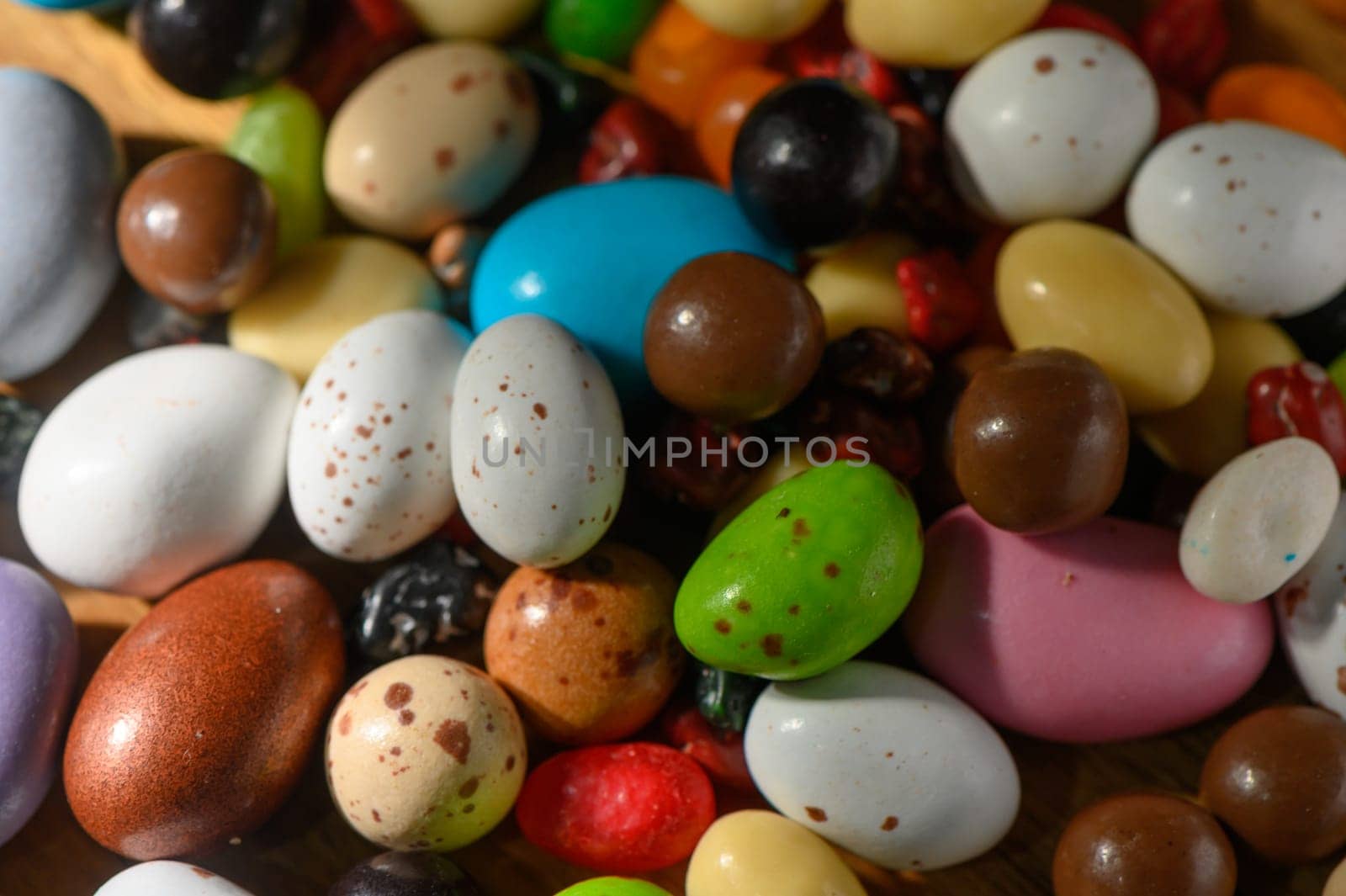 Vibrant candies of various shapes and colors delight the senses on a rustic wooden setting, ready to be enjoyed.