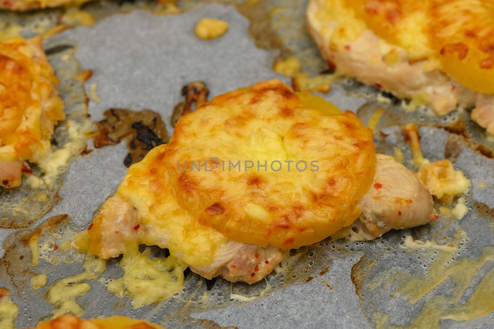 Juicy baked chicken pieces adorned with bubbling cheese and sweet pineapple, promising a flavorful culinary delight
