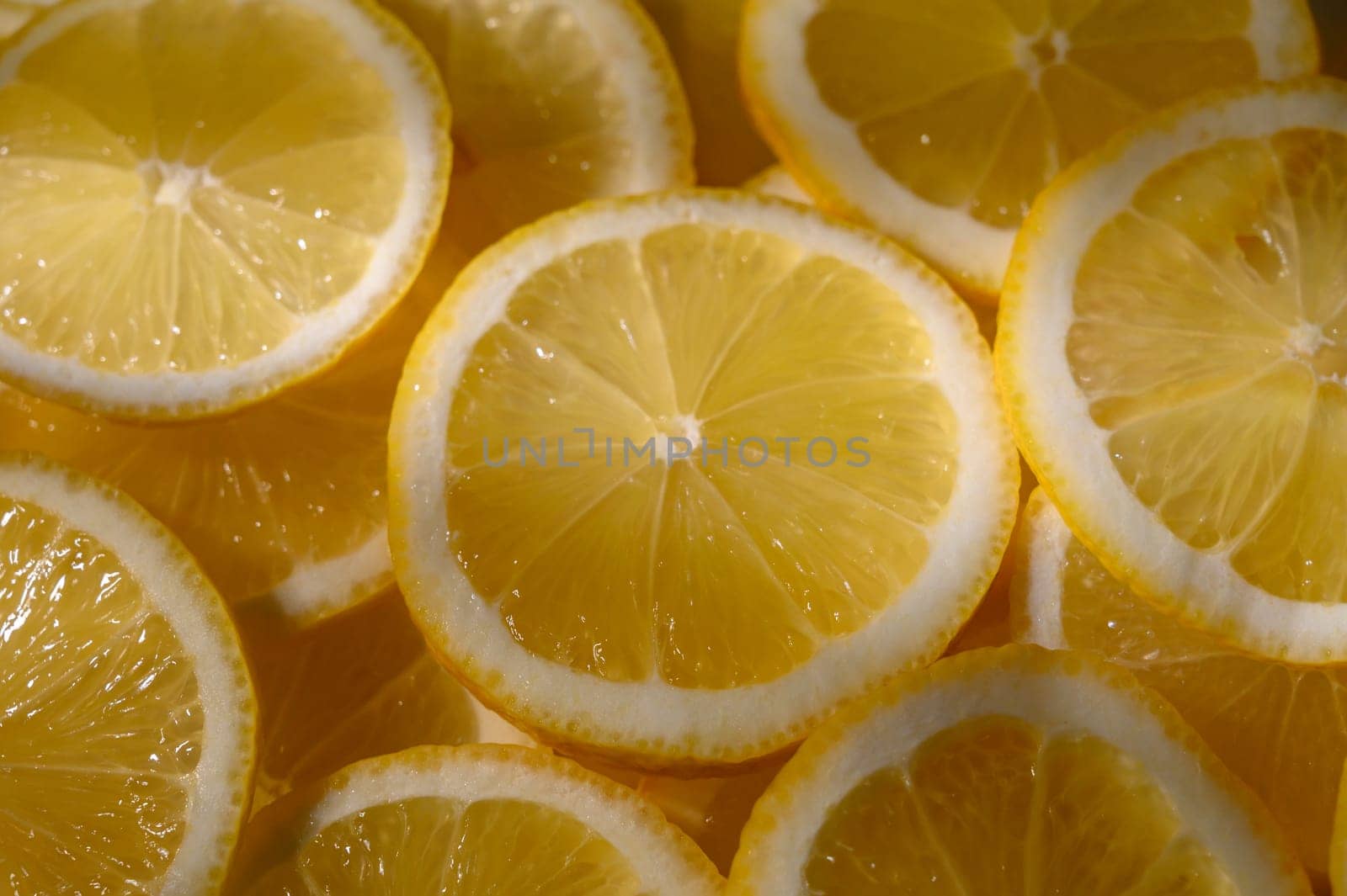 Circular lemon slices shine bright, showcasing their juicy flesh and zesty aroma in soft lighting.