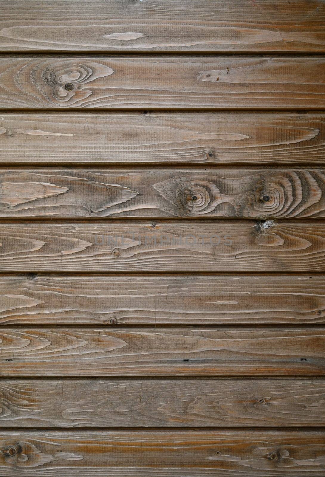 Warm hues and unique grain patterns of wooden planks create a welcoming atmosphere in a rustic interior space.