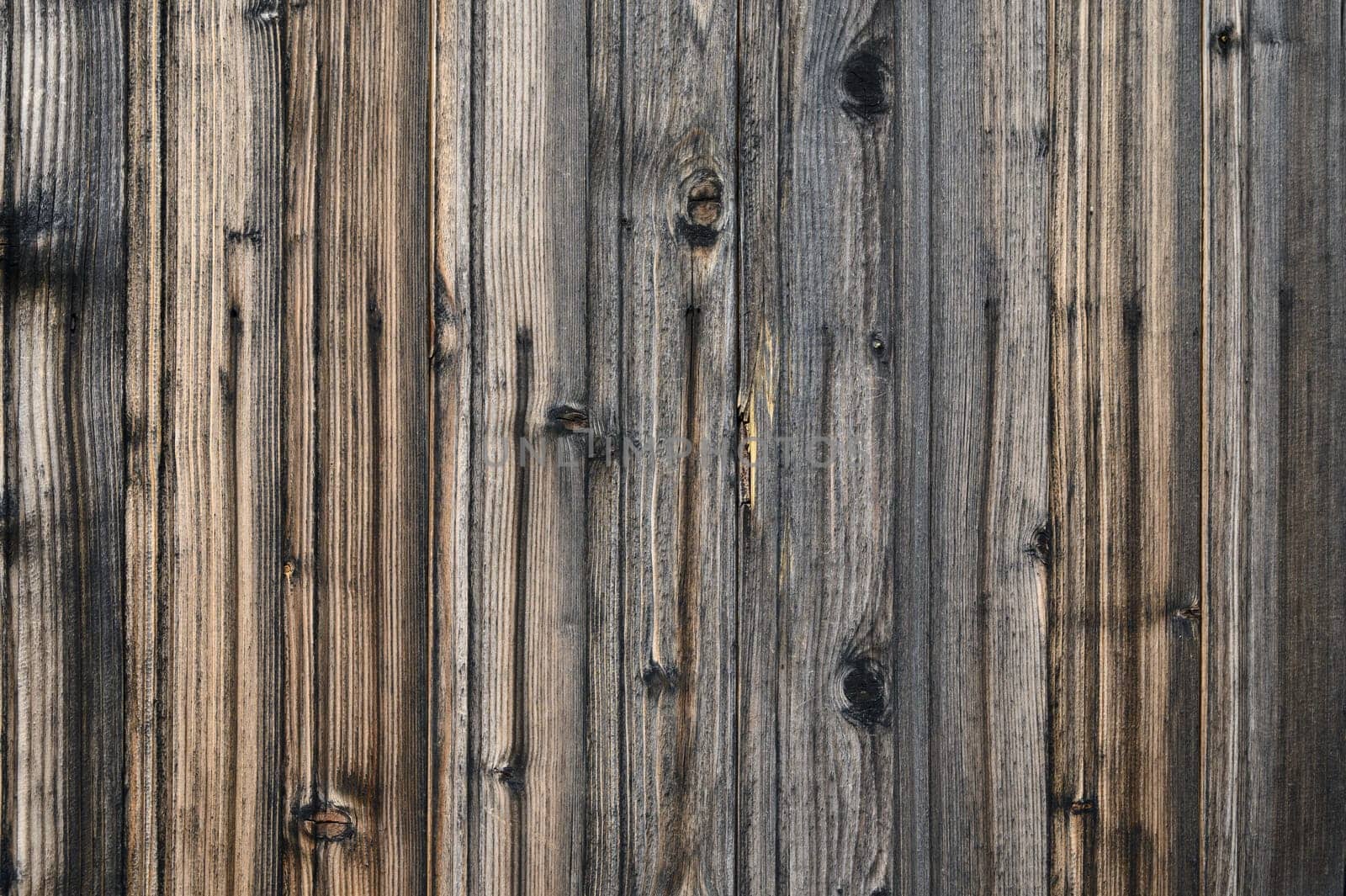 Weathered wooden boards display intricate patterns and rich tones that bring warmth to outdoor spaces and designs.