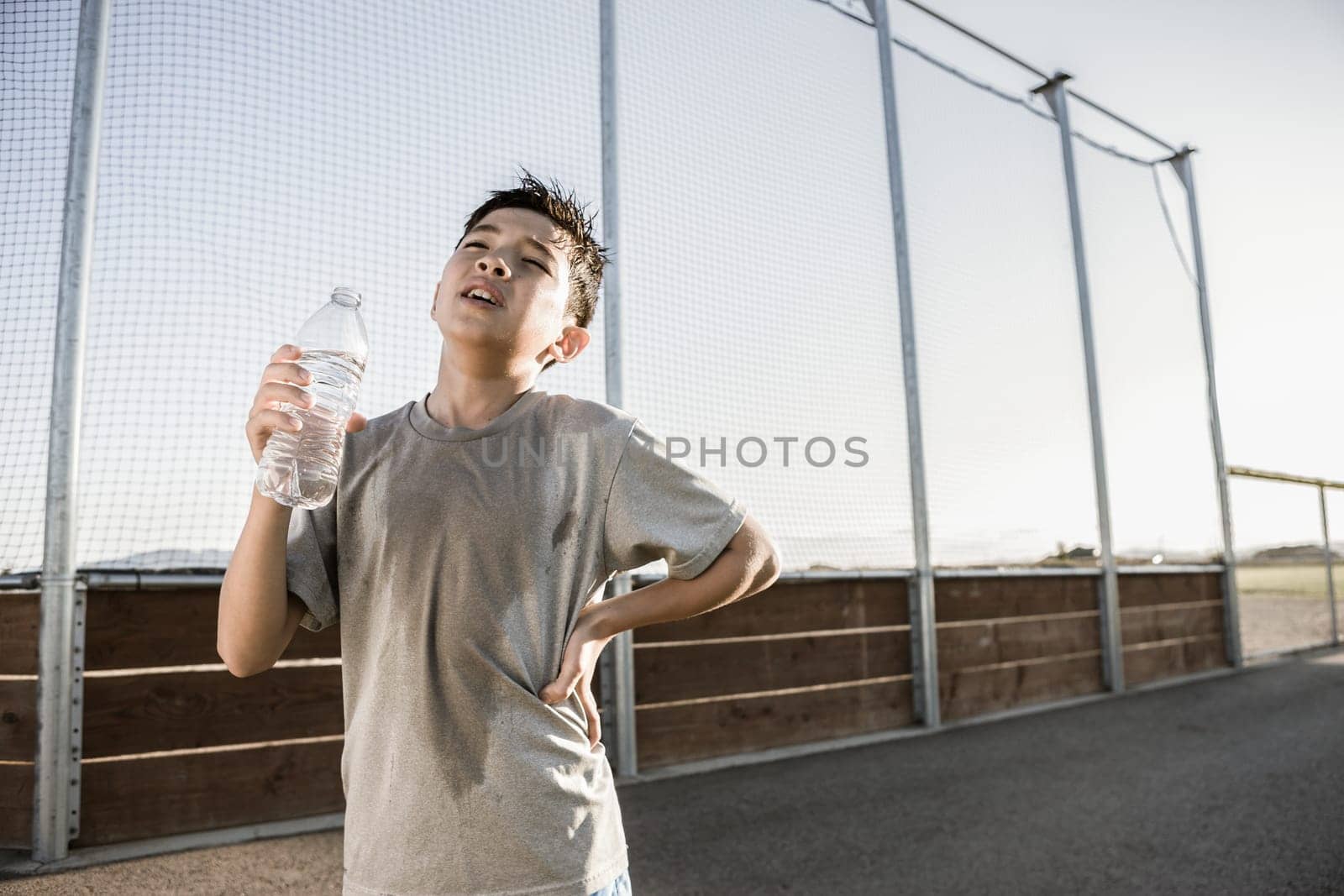A young boy shows how tired he is after a hard practice.