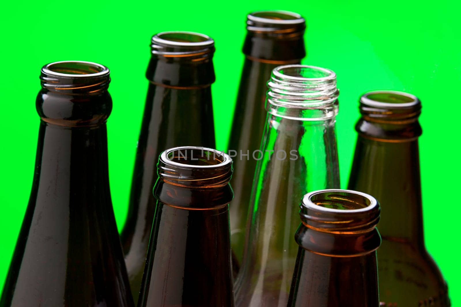 A close up of several brown glass bottles and one clear glass bottle.