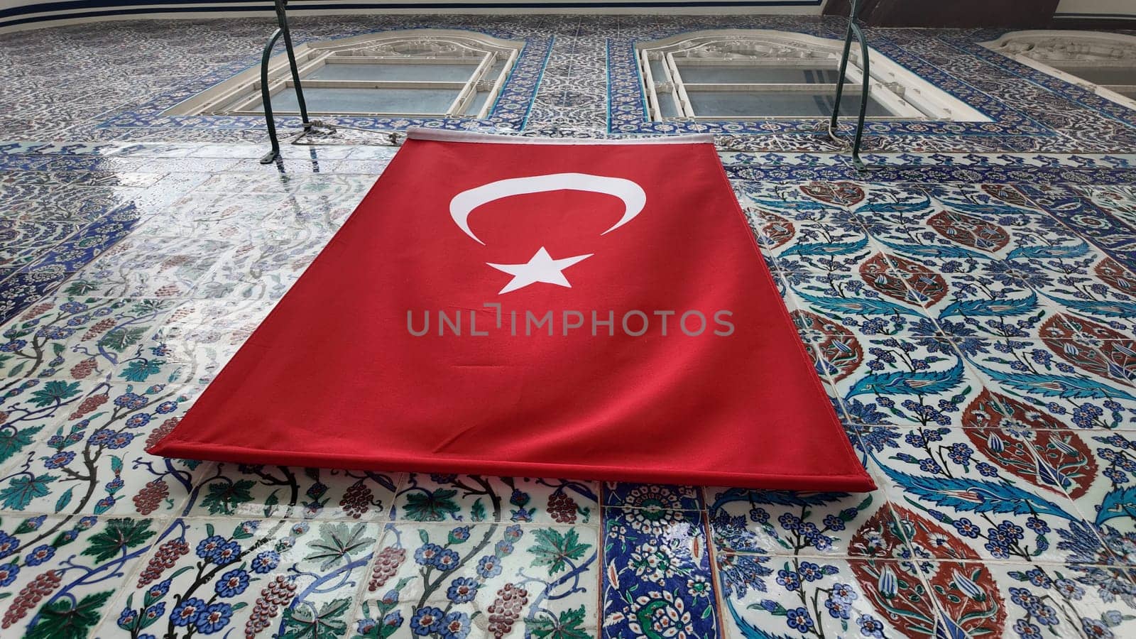 A vibrant Turkish flag hangs prominently against decorated tiles.