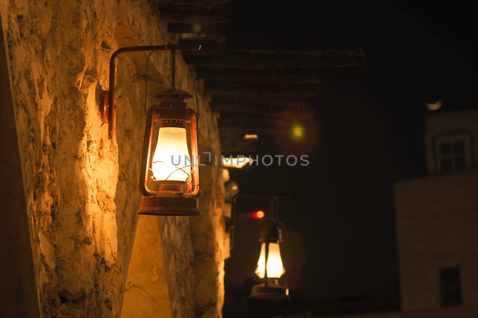 Warm light from lanterns enhances a tranquil night atmosphere outdoors.