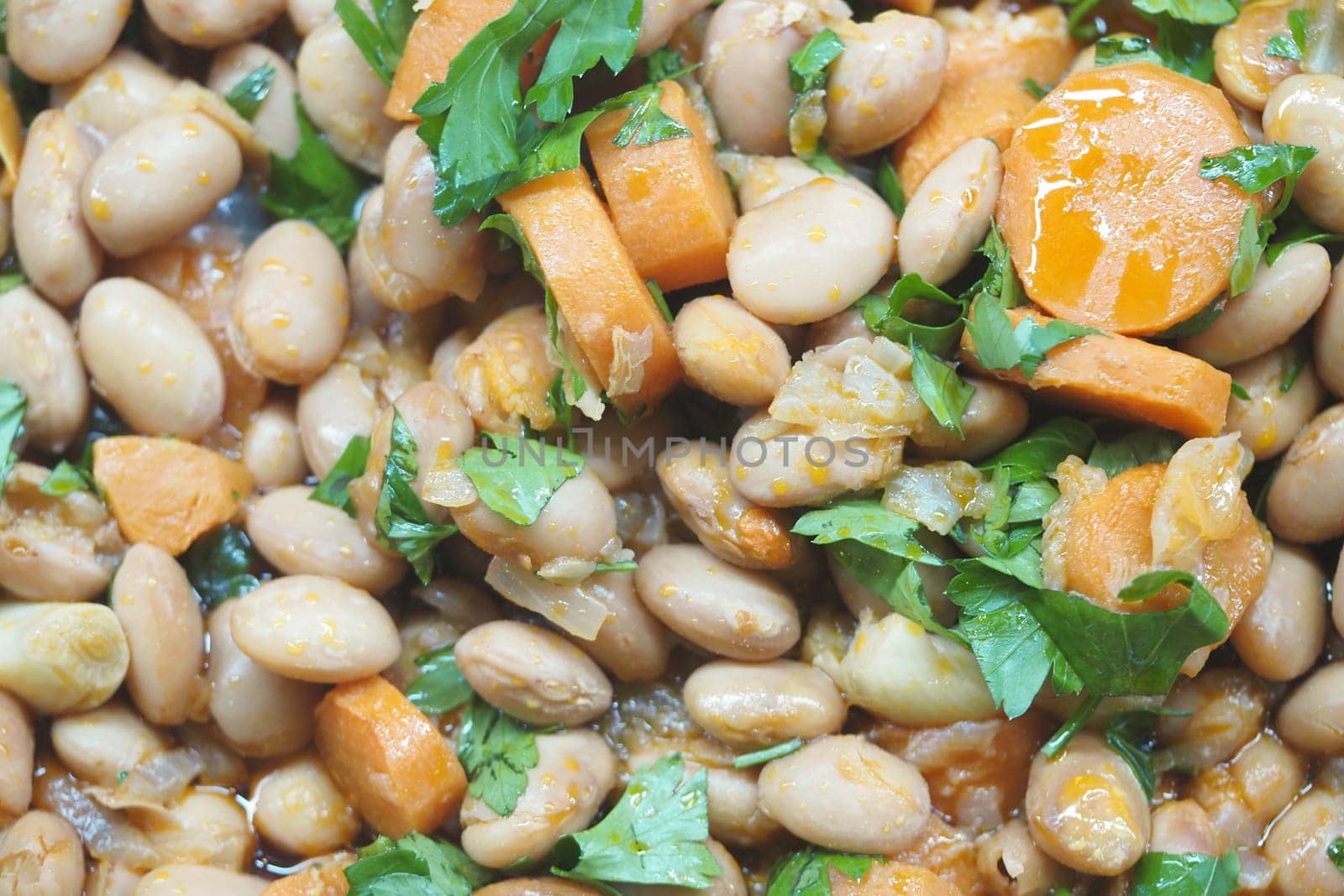 A tasty mix of white beans, carrots, and fresh herbs cooked together.