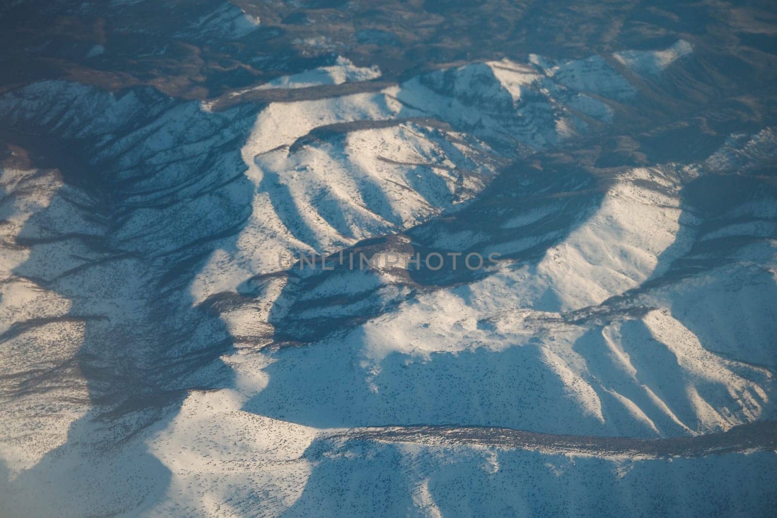 Vast snow-covered mountains stretch under clear skies, captivating any observer.
