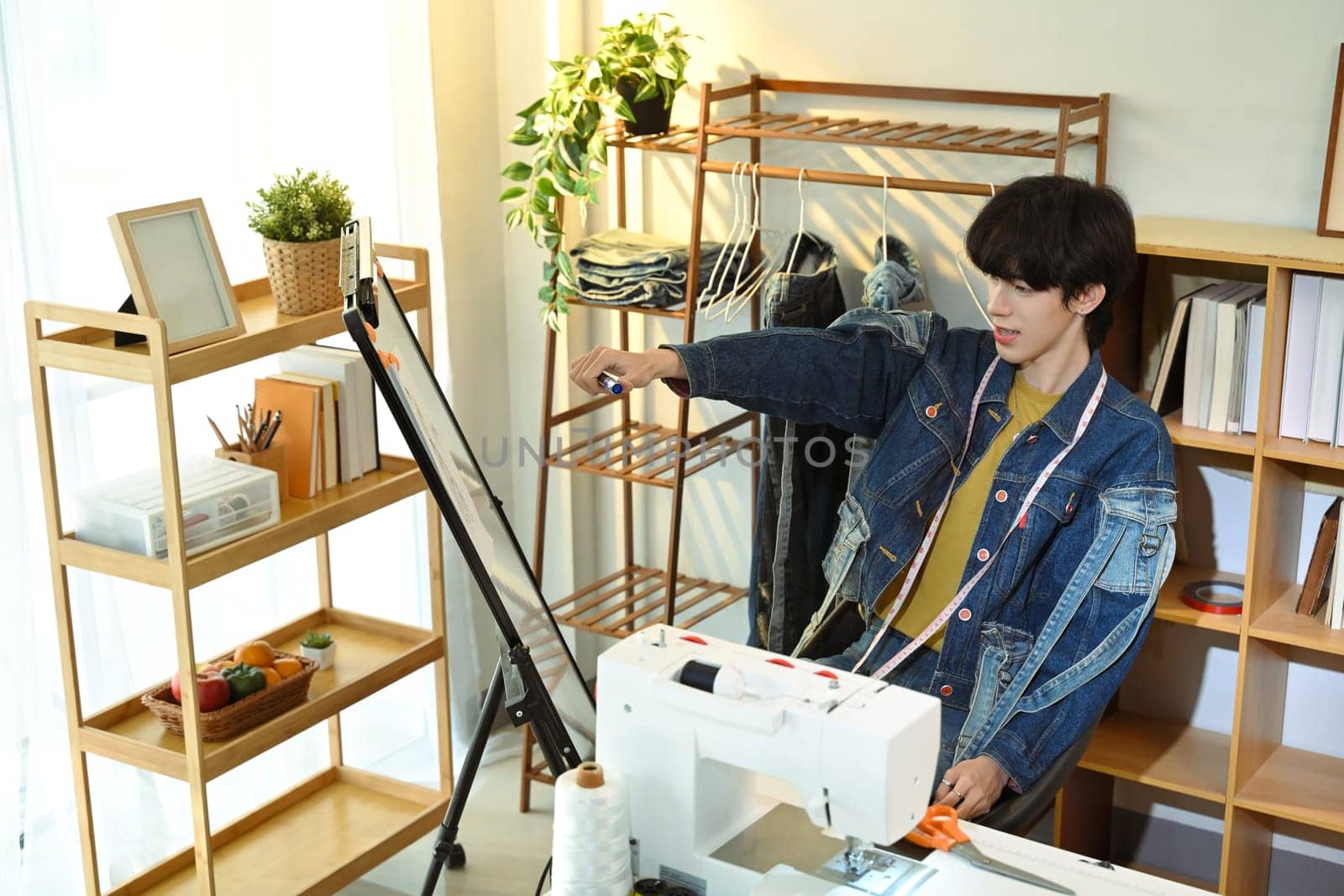 Fashion designer sketching or presenting ideas on a whiteboard.