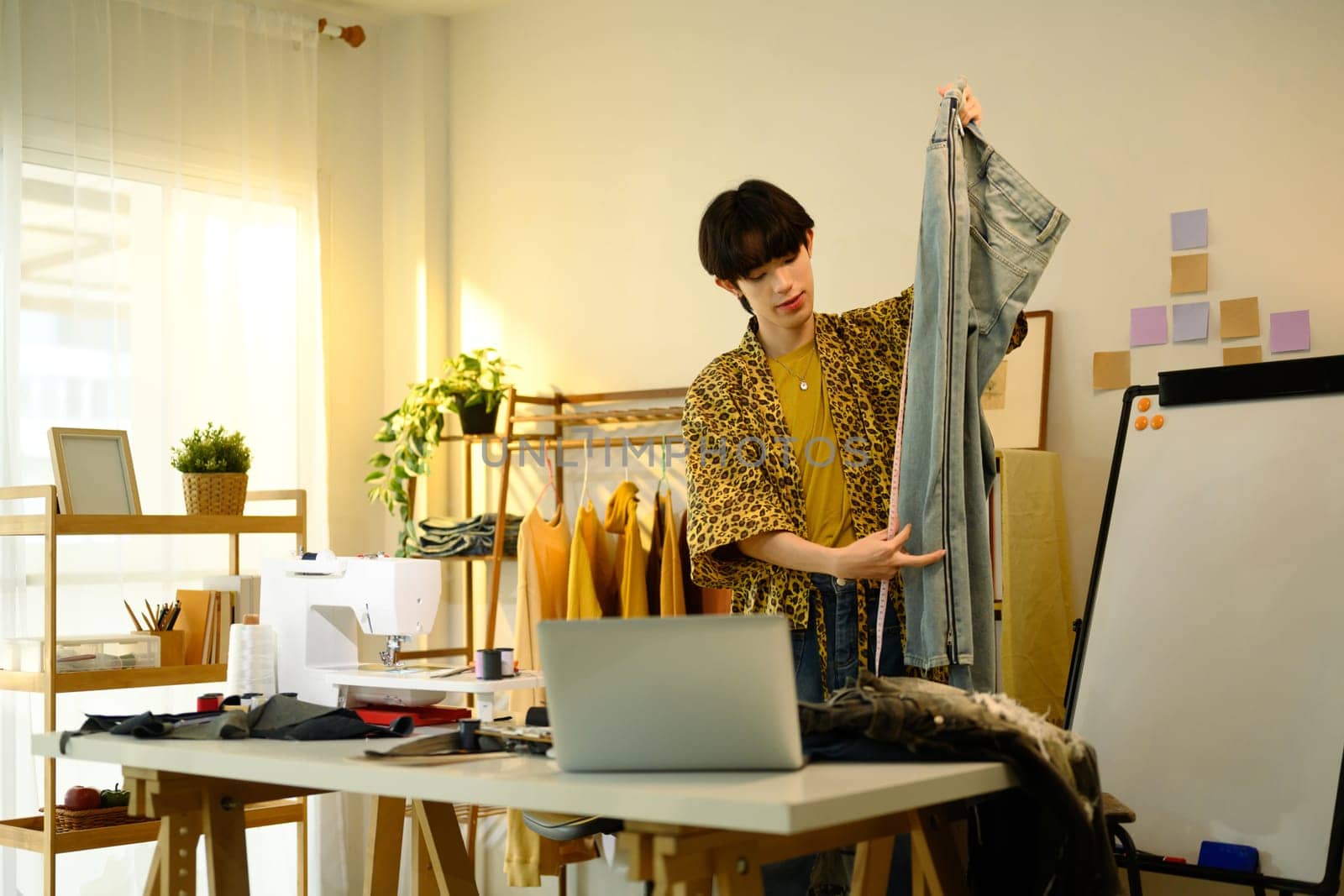 Creative fashion designer inspecting a pair of denim jeans in a creative studio.