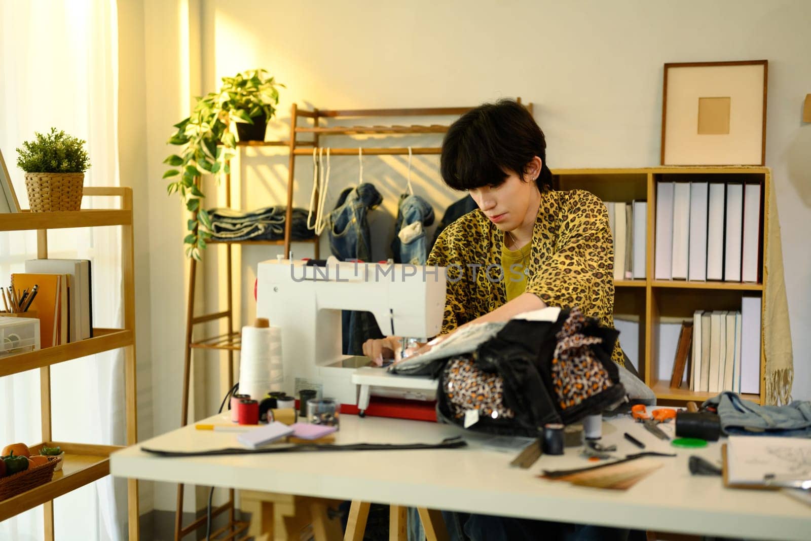 Fashion designer sewing custom garment in a creative studio.