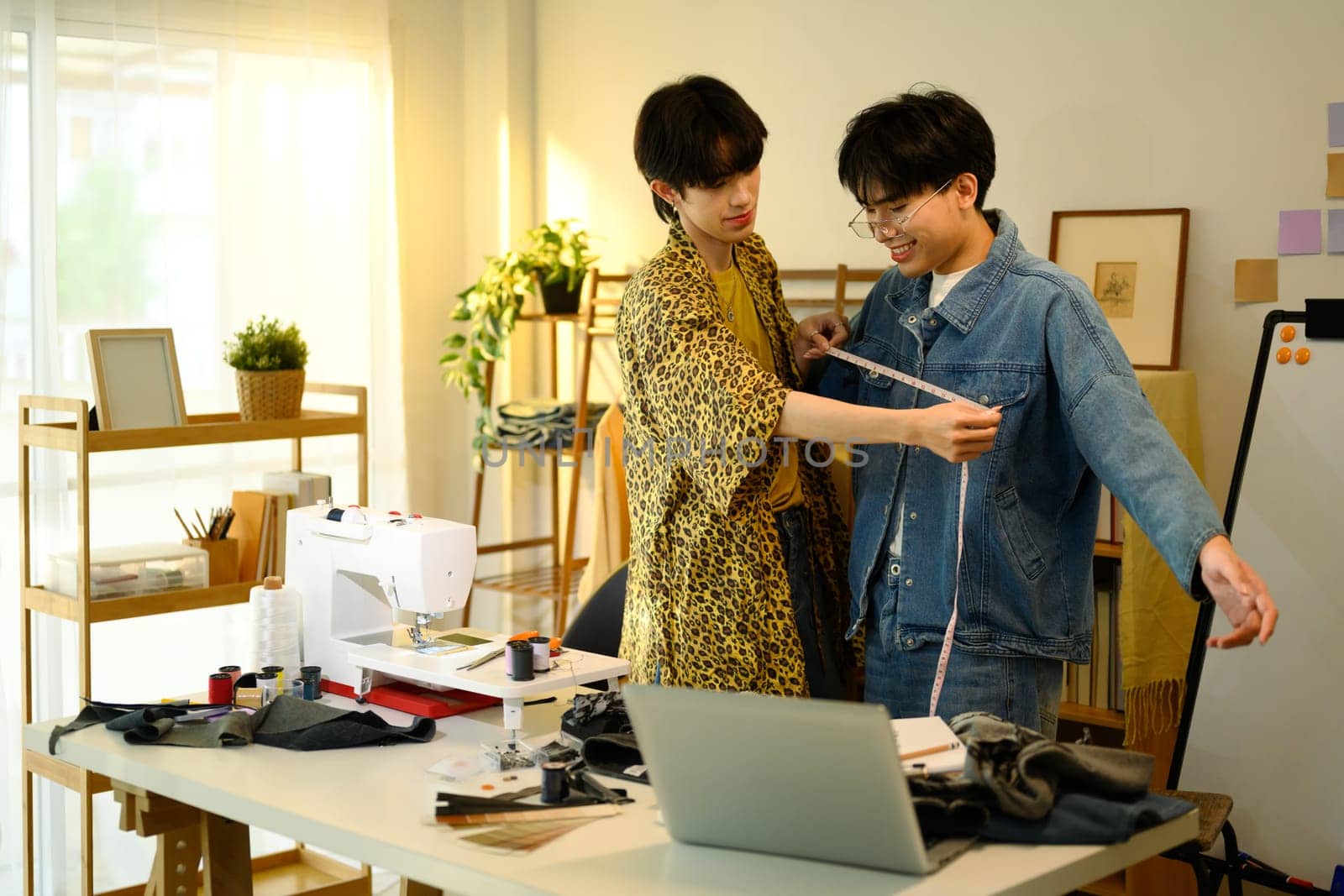 Two young designers brainstorming ideas while working on denim collection.