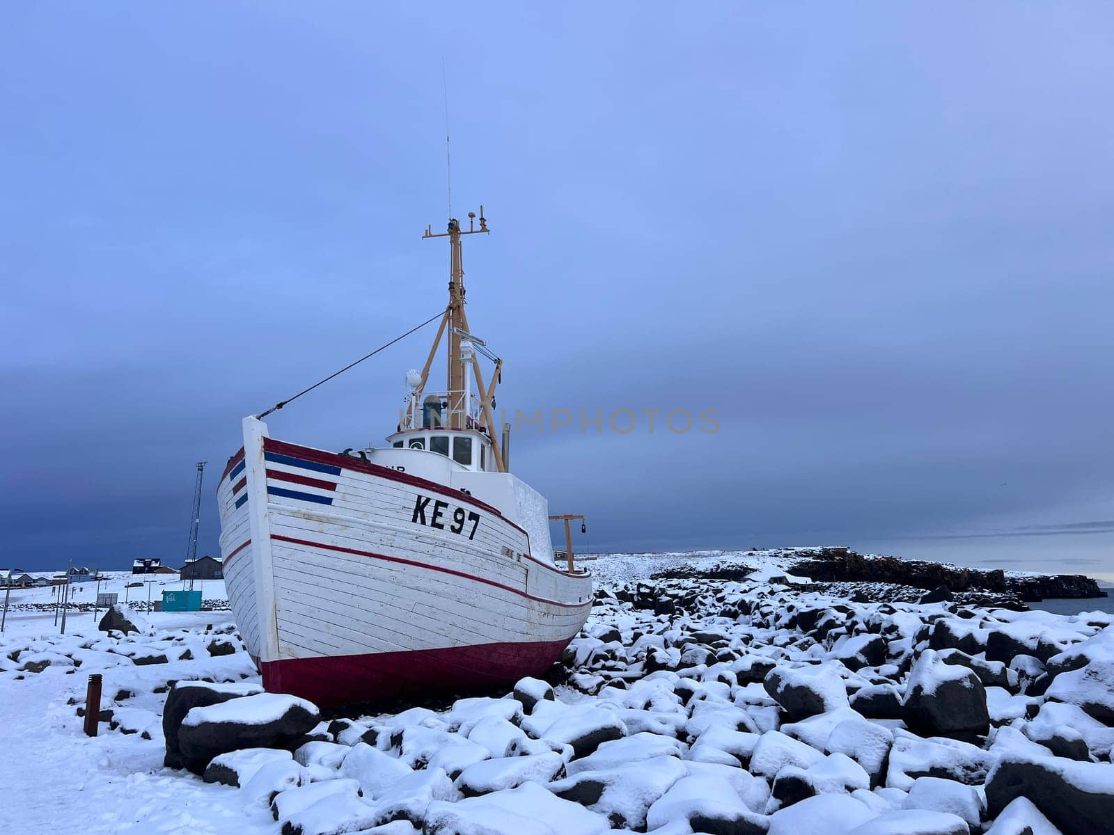 A boat waits for spring on a rocky beach of Keflavik in Iceland. High quality photo