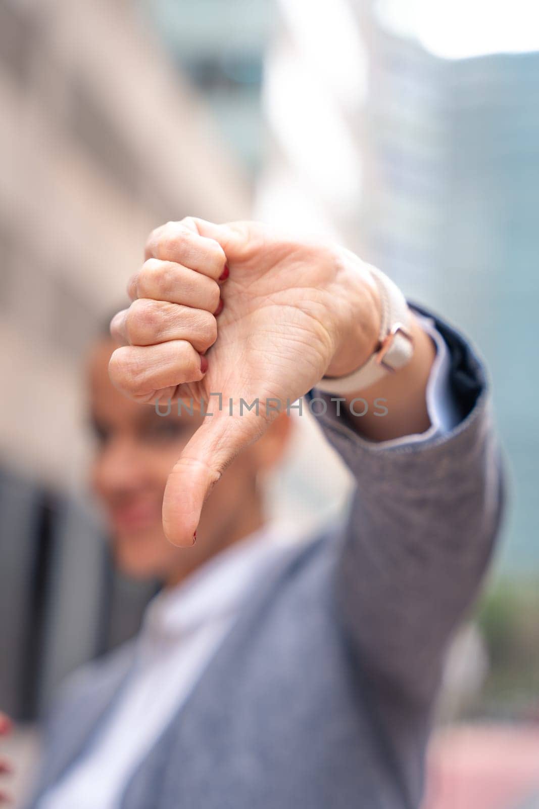 Middle adult woman, Caucasian woman, pointing with thumbs down. Angry facial expression.