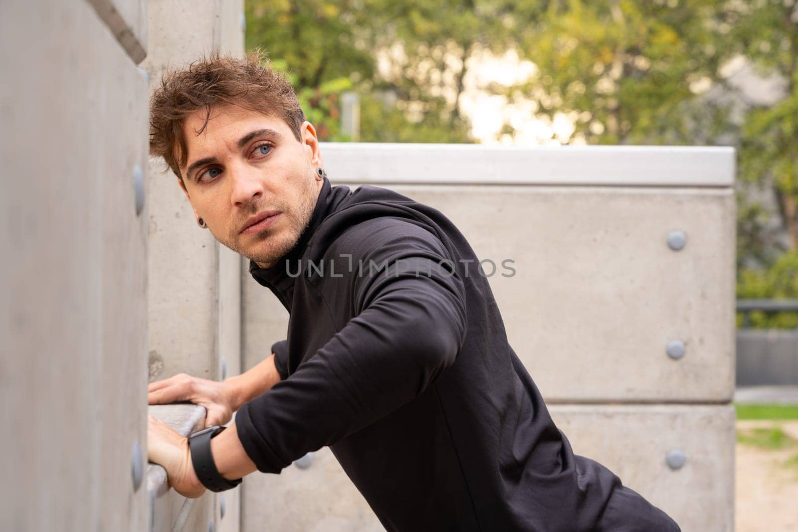 Side view male runner doing stretching exercises before running or doing cardio exercise.