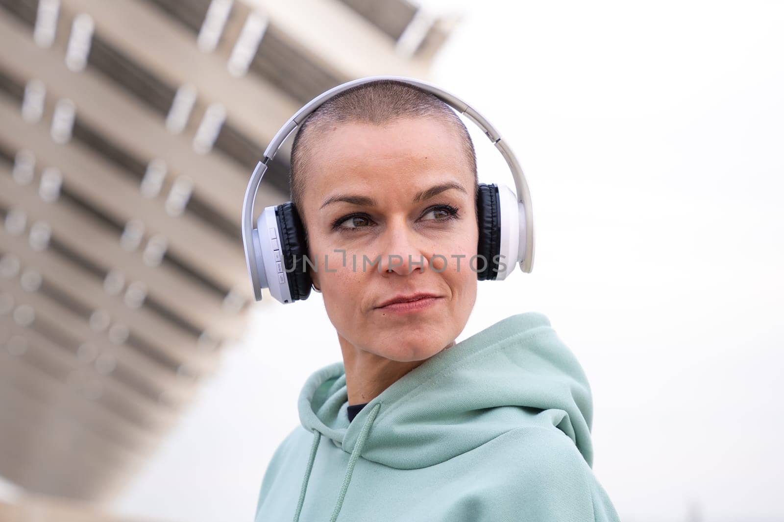 Portrait Fit woman smiling at camera with headphones on. Woman having fun during her morning workout.