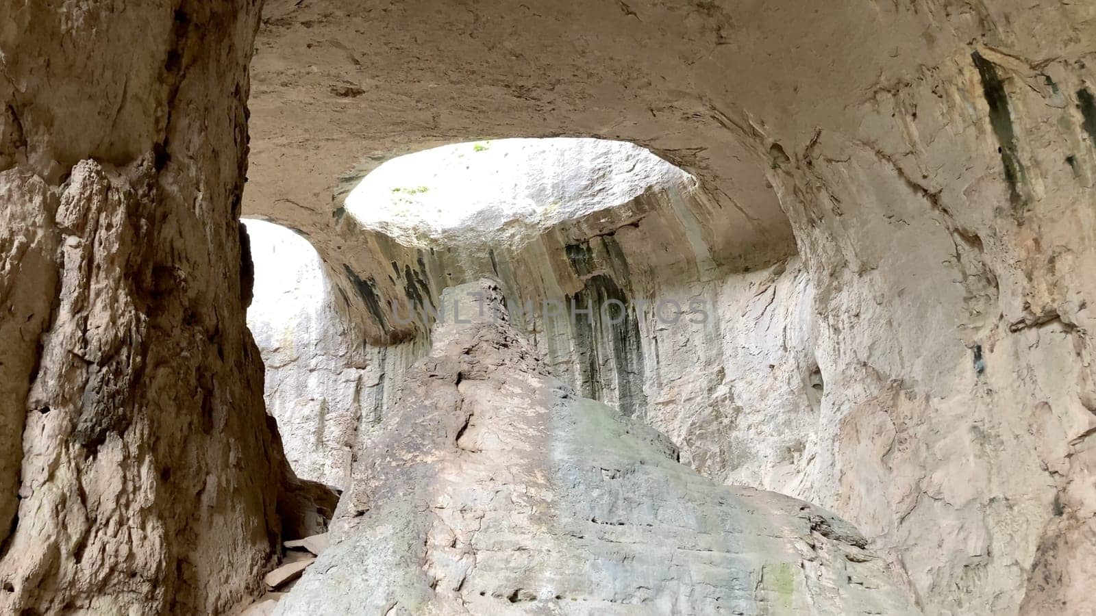 Prohodna Cave in Bulgaria, featuring the iconic God's Eyes openings, a natural rock formation resembling eyes. Majestic natural wonder. Dramatic light filters from the holes above - Karlukovo, Europe