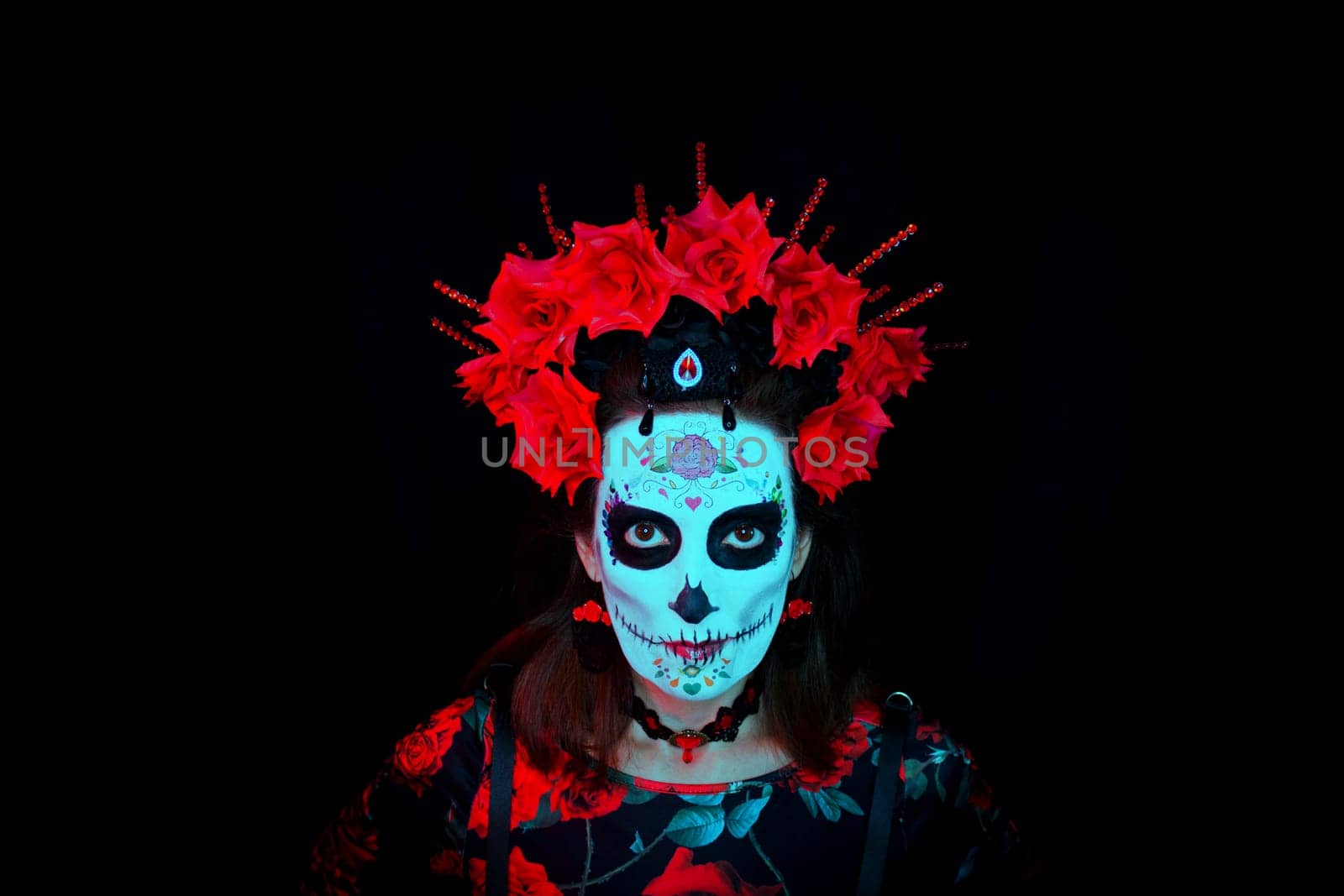 Woman dressed as a Mexican Catrina with a crown of red and black flowers