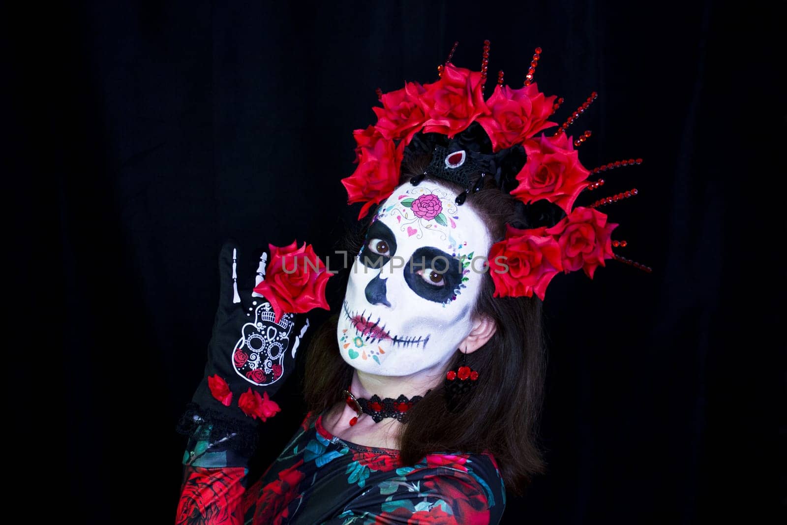 Woman dressed as a Mexican Catrina with a crown of red and black flowers