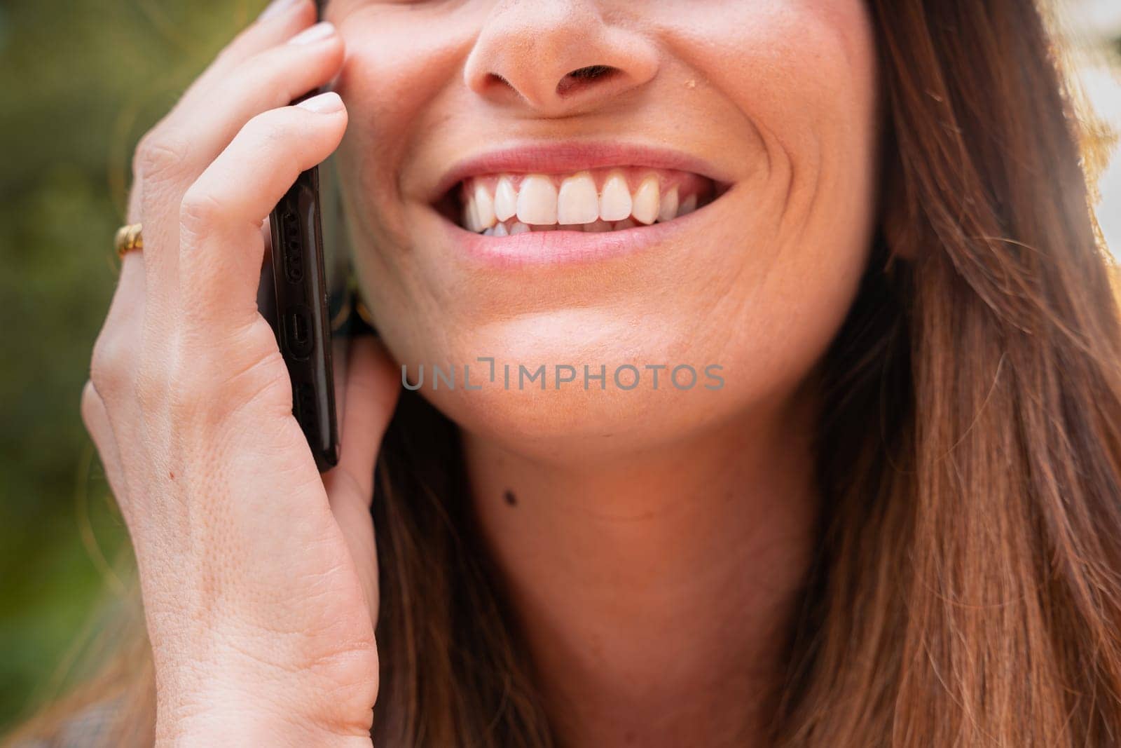 Portrait Happy young Woman With Perfect White Teeth Smiling On telephone.