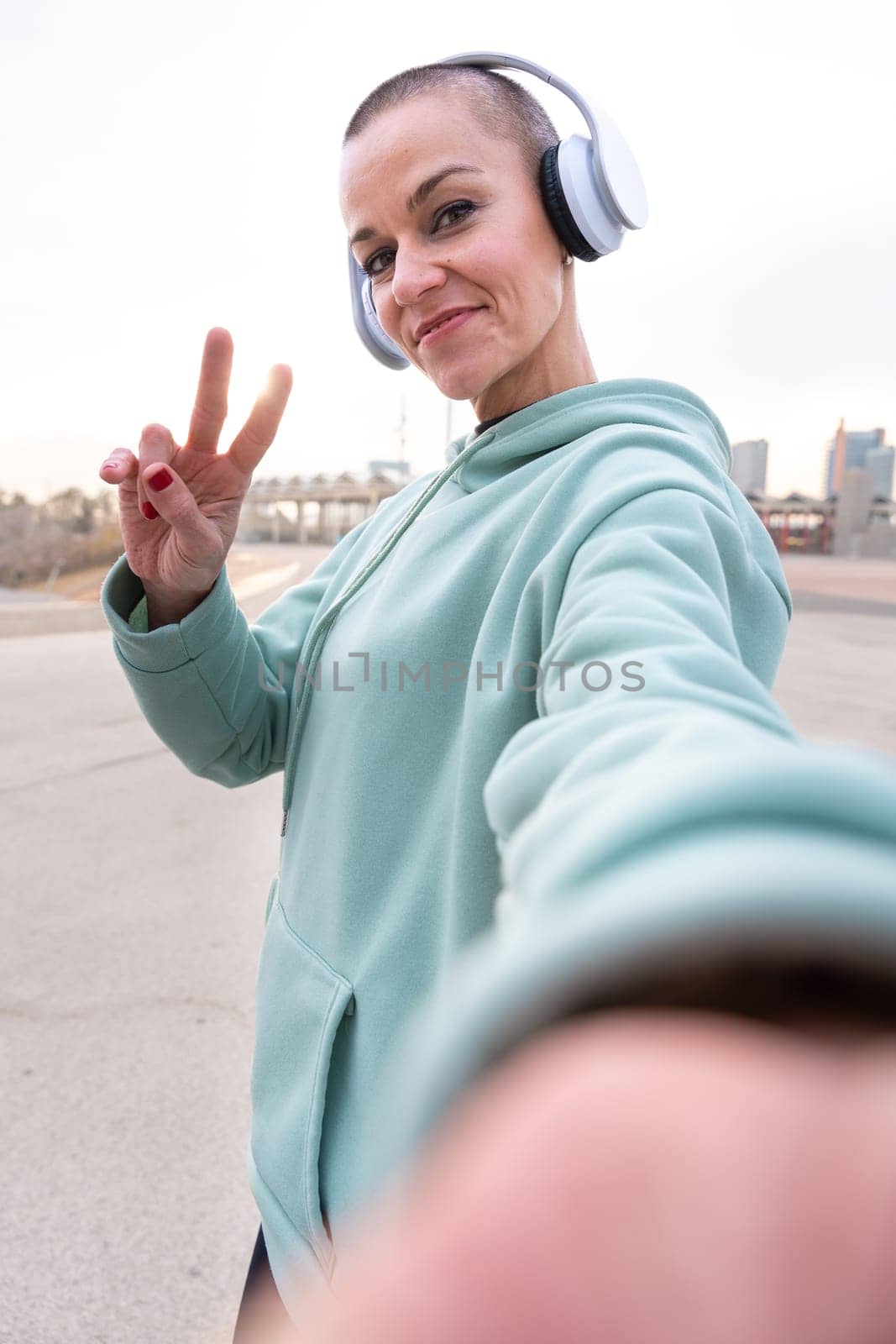 Sporty woman taking a break taking a self-portrait with her cell phone looking at camera