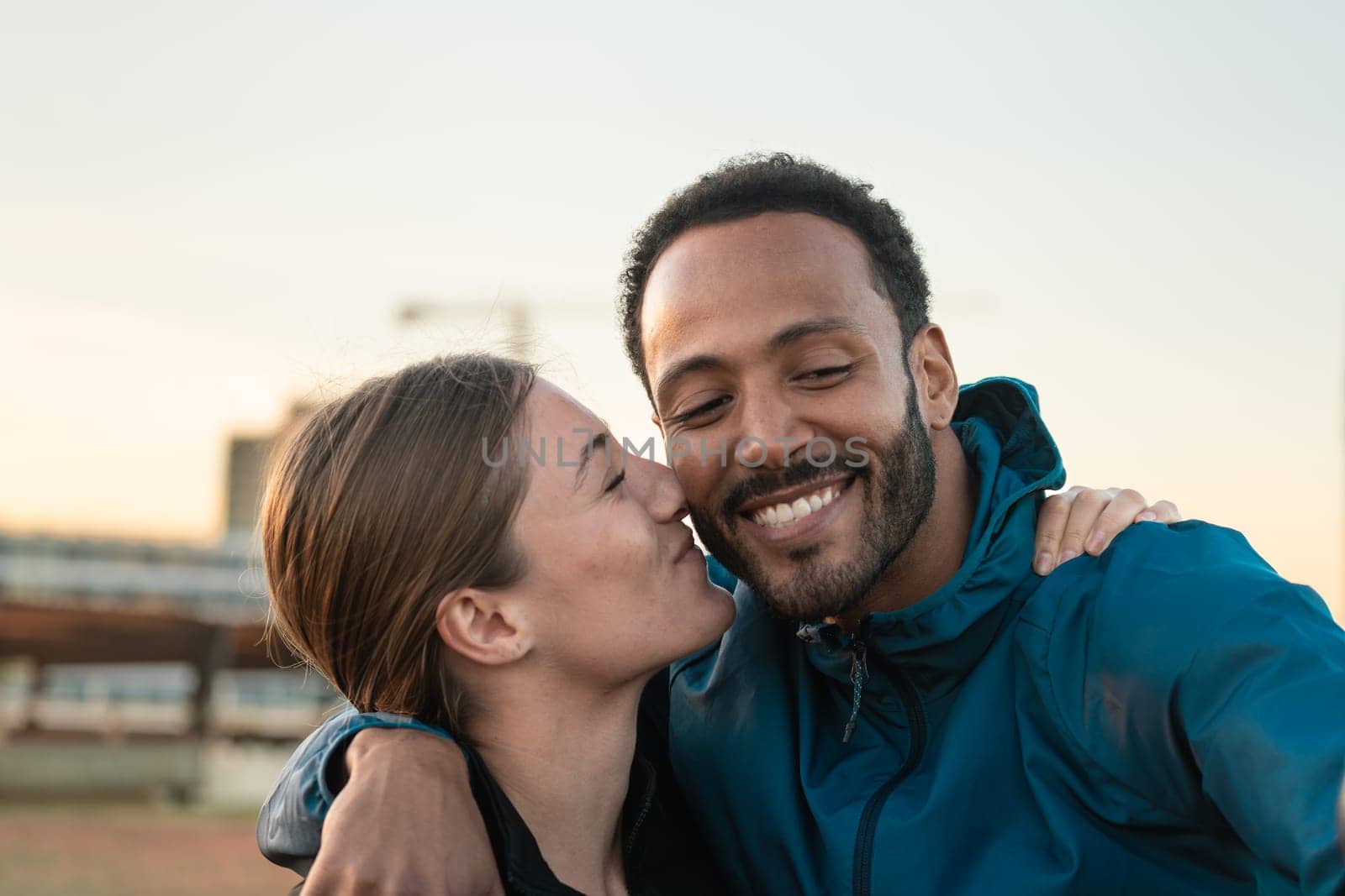 Happy, smiling, affectionate and sporty friends kissing, ready to exercise or train.