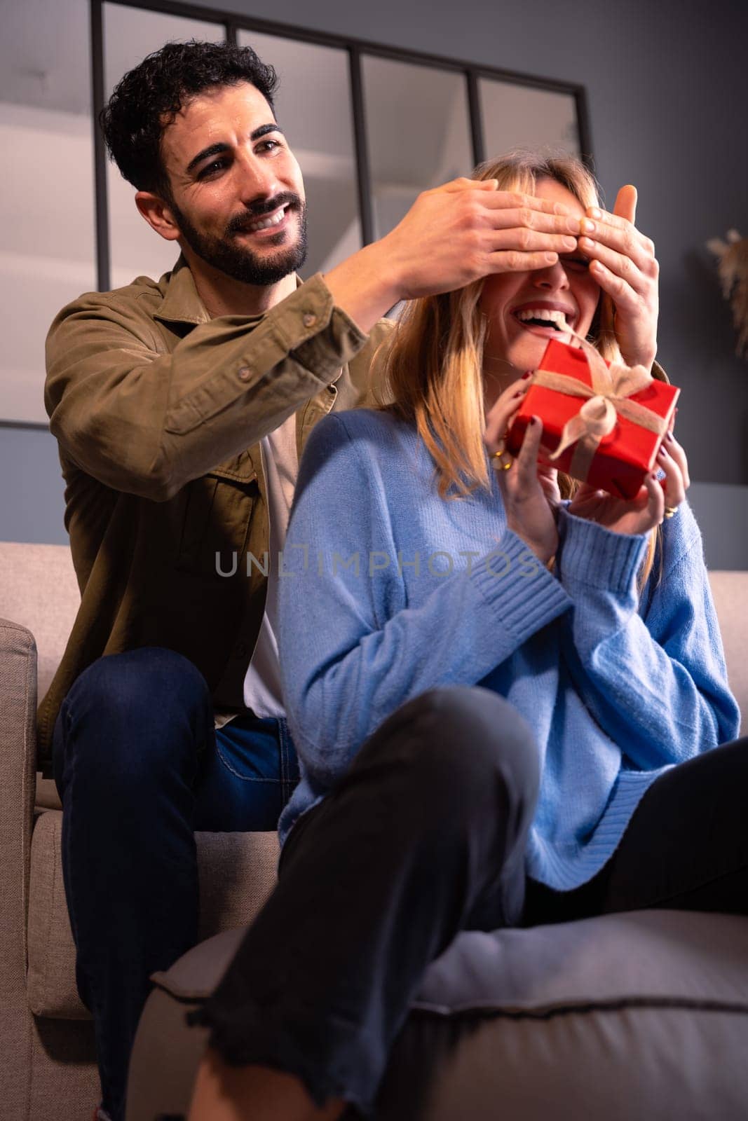 Beautiful young couple enjoying time together while celebrating Valentine's Day giving gifts.