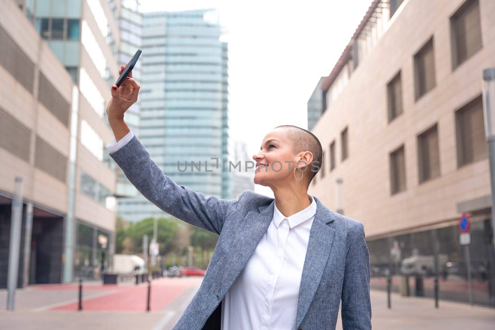Beautiful happy caucasian adult woman in costume smiling taking a selfie outdoors.