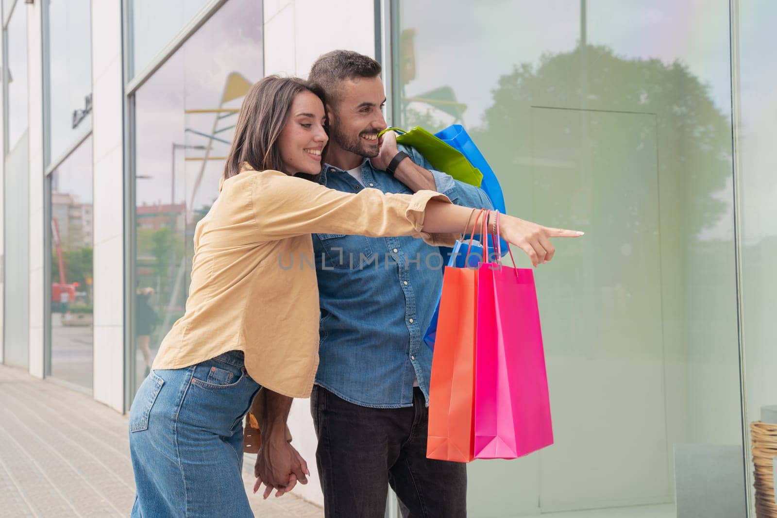 girl and boy holding shopping bags and searching retail stores.