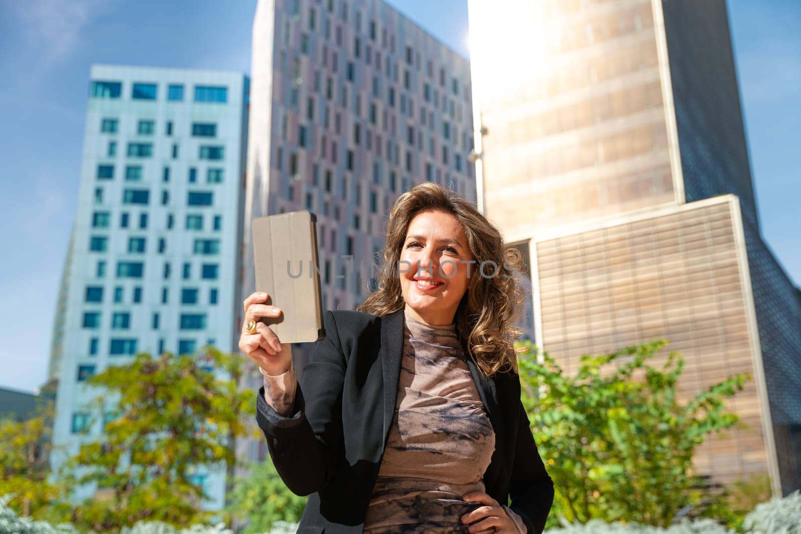Portrait of a smiling middle-aged business woman with digital tablet in smiling hands looking at camera