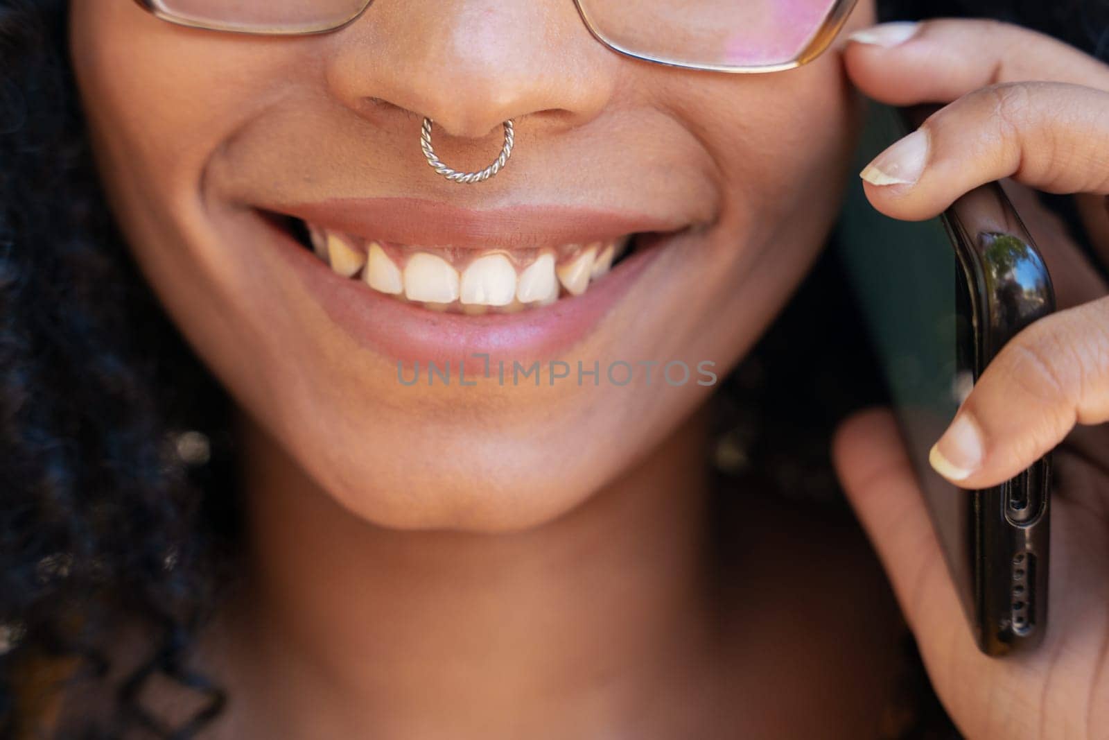 Young smiling black student talking on mobile phone on college campus. Concept: University Life